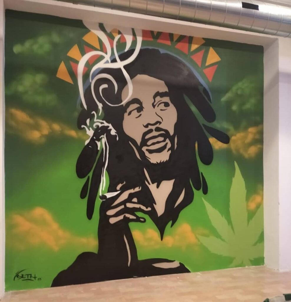 Graffiti mural de Bob Marley, capturando la esencia del legendario músico de reggae.