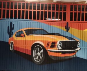 Graffiti de coche clásico en persiana de parking, añadiendo un toque retro.