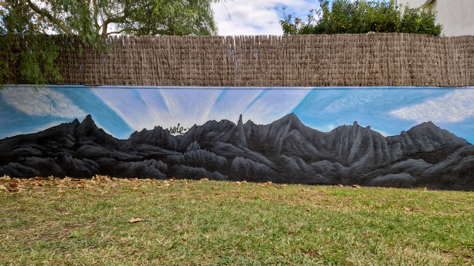 Mural de paisajes de montañas con detalles de naturaleza y cielos despejados.